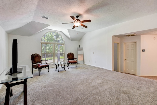 living area with a textured ceiling, ceiling fan, light colored carpet, and vaulted ceiling