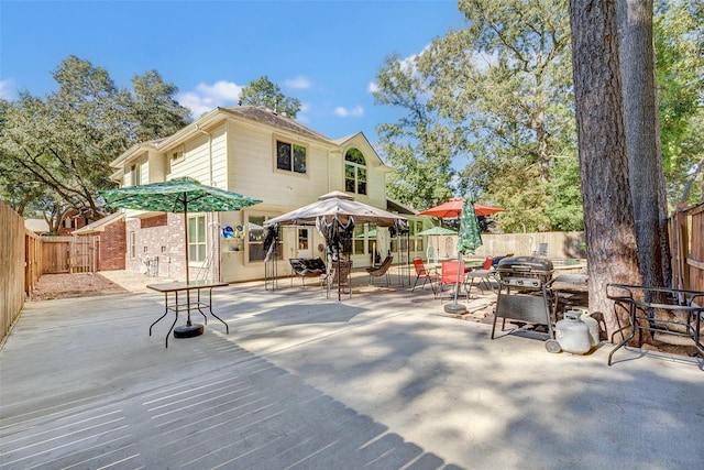 31202 Deerwood Park Ln, Spring City, TX 77386 - back of property with a patio, a fenced backyard, brick siding, and outdoor dining space
