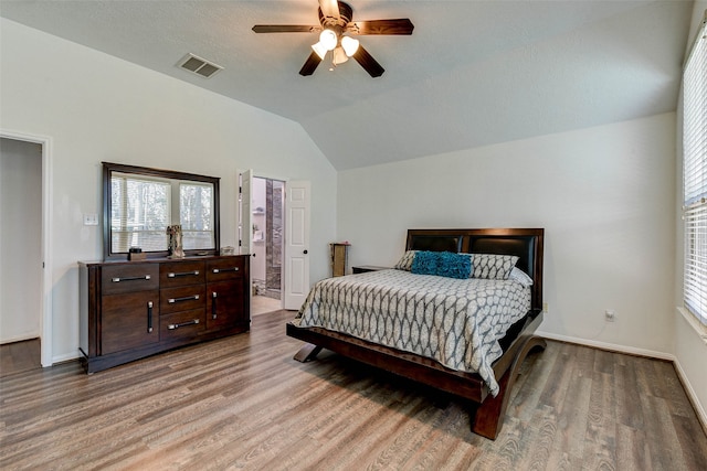 bedroom with ceiling fan, hardwood / wood-style floors, and lofted ceiling