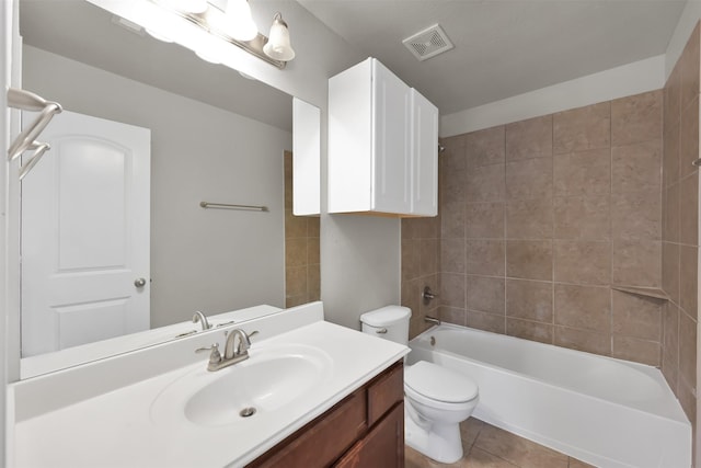 full bathroom featuring tile patterned flooring, vanity, tiled shower / bath combo, and toilet