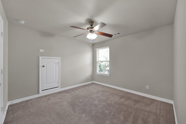 carpeted spare room with ceiling fan