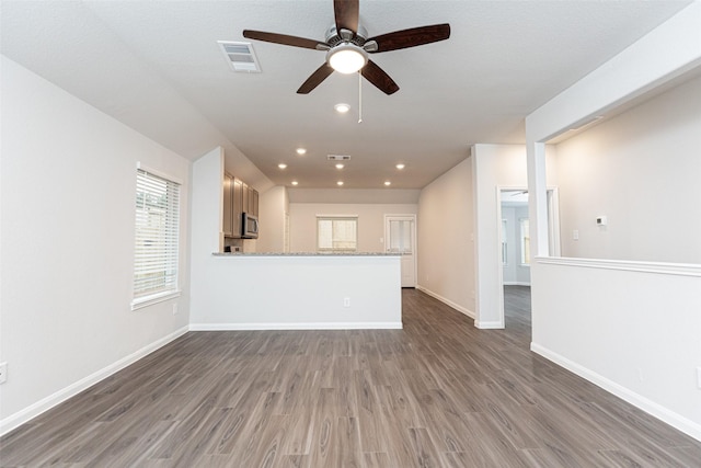 unfurnished living room with ceiling fan and dark hardwood / wood-style flooring