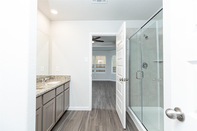 bathroom with walk in shower, ceiling fan, vanity, and hardwood / wood-style flooring