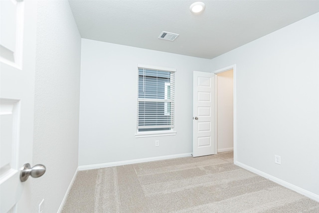 spare room featuring light colored carpet