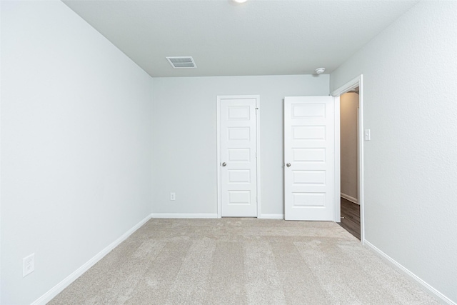 unfurnished bedroom with light colored carpet