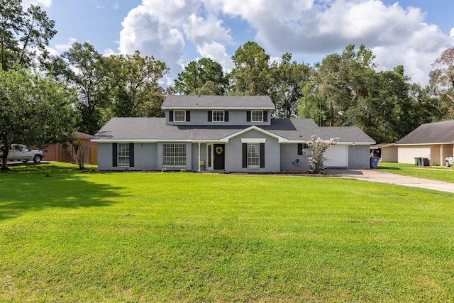 view of property with a garage and a front lawn