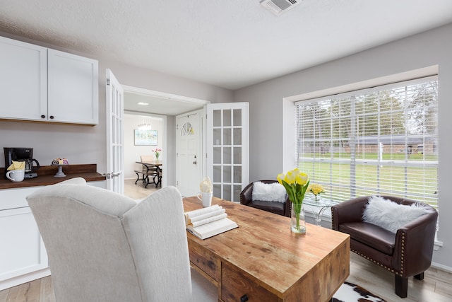 dining area featuring a textured ceiling and light hardwood / wood-style floors