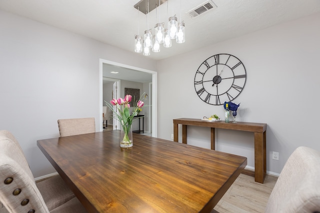 dining room featuring light hardwood / wood-style floors and an inviting chandelier