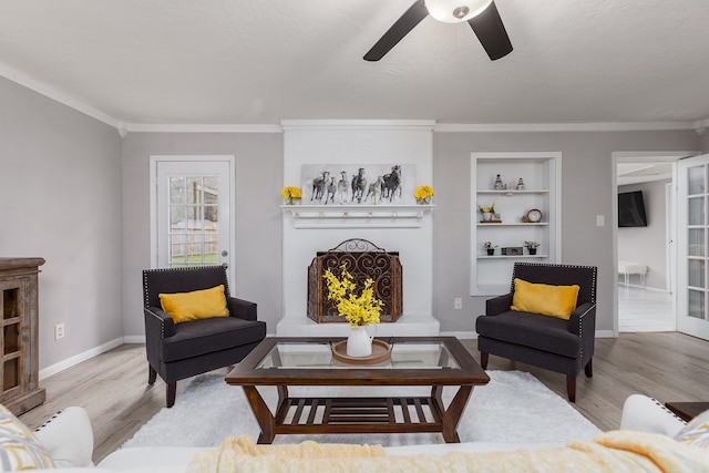 living room featuring ceiling fan, light wood-type flooring, and ornamental molding