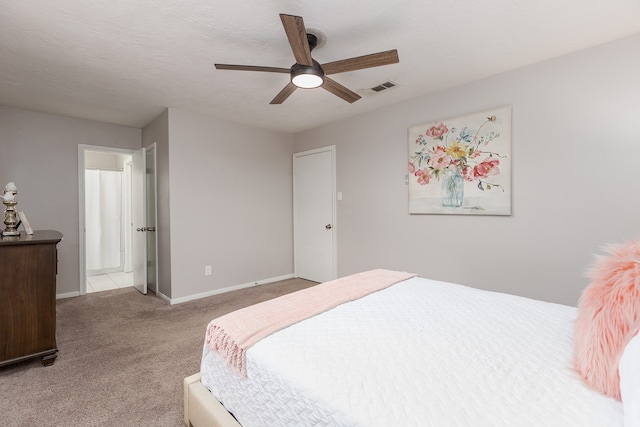 carpeted bedroom featuring a textured ceiling and ceiling fan