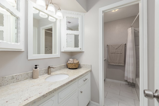 bathroom featuring shower / bathtub combination with curtain, tile patterned flooring, and vanity