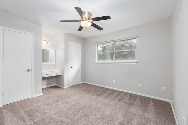 unfurnished bedroom with light carpet and ceiling fan