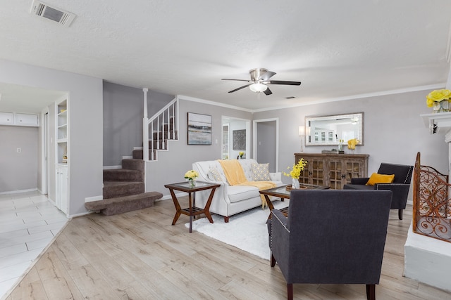 living room with crown molding, ceiling fan, a textured ceiling, and light wood-type flooring