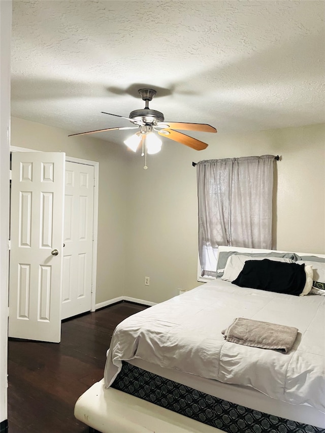 bedroom with ceiling fan, dark hardwood / wood-style floors, and a textured ceiling