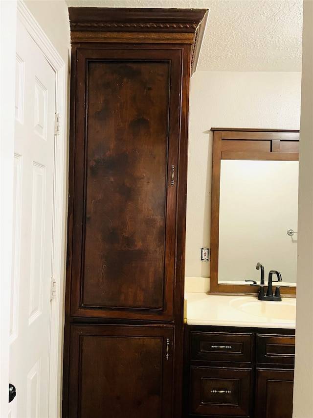 interior details with vanity and a textured ceiling