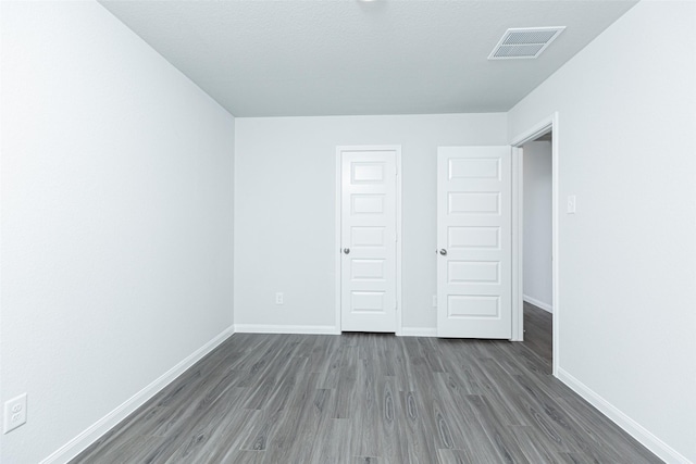 unfurnished bedroom featuring dark hardwood / wood-style floors and a closet