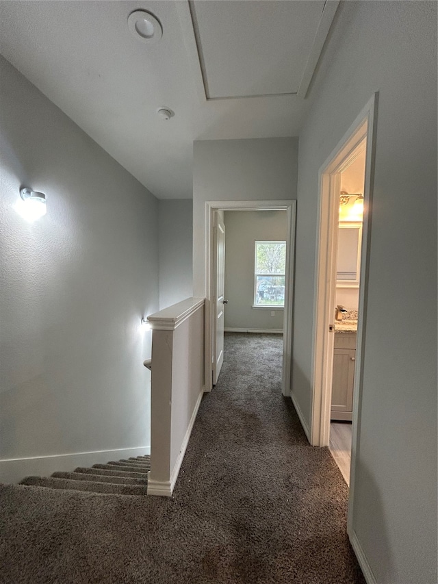 hallway featuring dark carpet