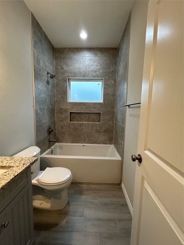 full bathroom with toilet, vanity, and tiled shower / bath combo