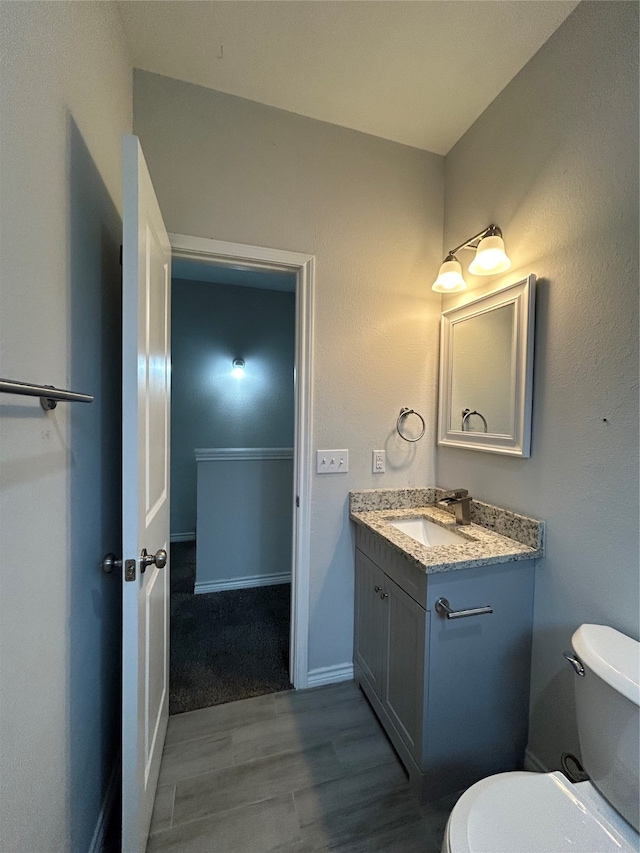 bathroom featuring hardwood / wood-style floors, vanity, and toilet