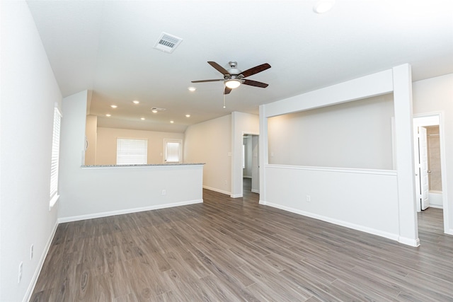 unfurnished living room featuring ceiling fan and dark hardwood / wood-style flooring