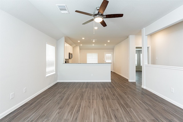 unfurnished living room with dark hardwood / wood-style flooring and ceiling fan