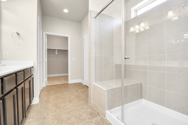 bathroom with tile patterned flooring, vanity, and walk in shower