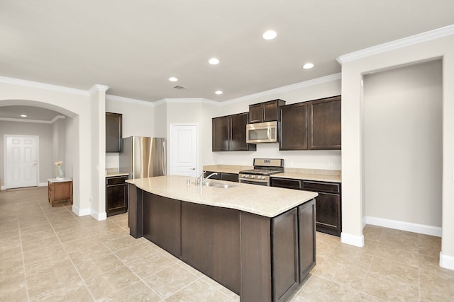 kitchen with a kitchen island with sink, dark brown cabinets, ornamental molding, and appliances with stainless steel finishes