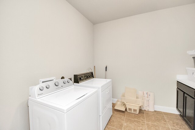 clothes washing area with cabinets, independent washer and dryer, and light tile patterned floors