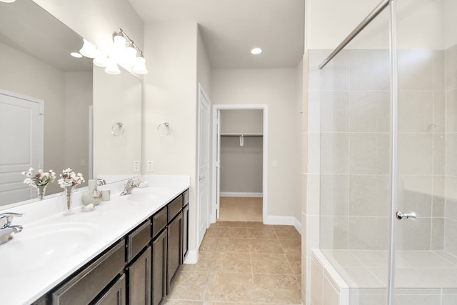 bathroom with a tile shower, vanity, and tile patterned floors