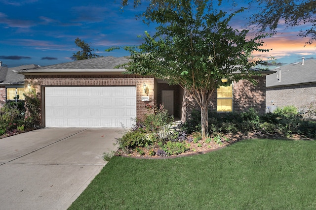 view of front facade featuring a garage and a yard