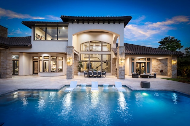 back house at dusk featuring an outdoor hangout area and a patio