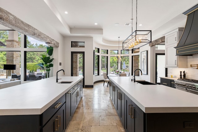 kitchen with sink, hanging light fixtures, and a large island with sink