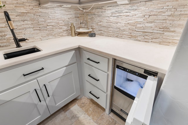 kitchen featuring wine cooler, sink, and white cabinetry