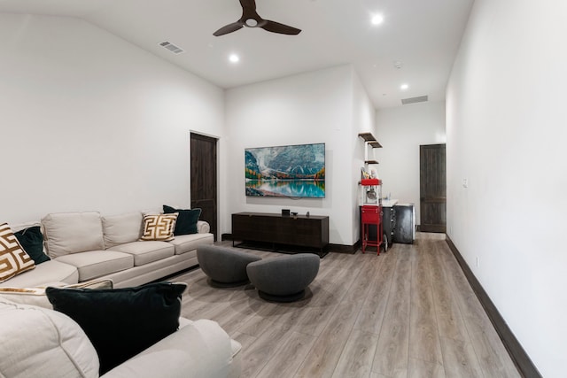 living room featuring lofted ceiling, light hardwood / wood-style flooring, and ceiling fan