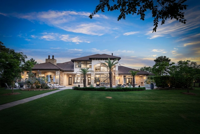 view of front of house with a yard and french doors