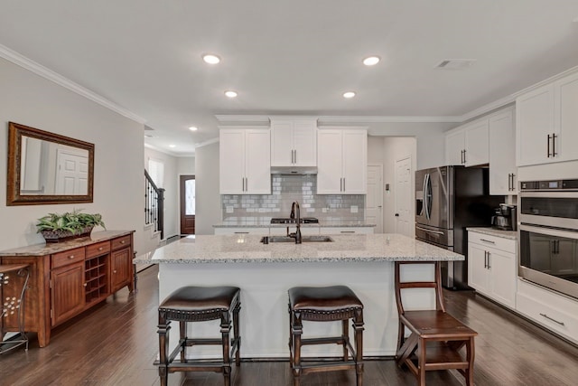 kitchen with a kitchen island with sink, crown molding, white cabinets, and dark hardwood / wood-style floors