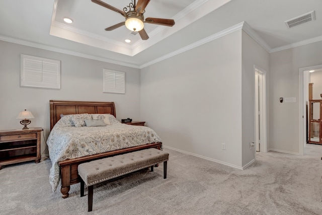 carpeted bedroom with ceiling fan, crown molding, and a tray ceiling