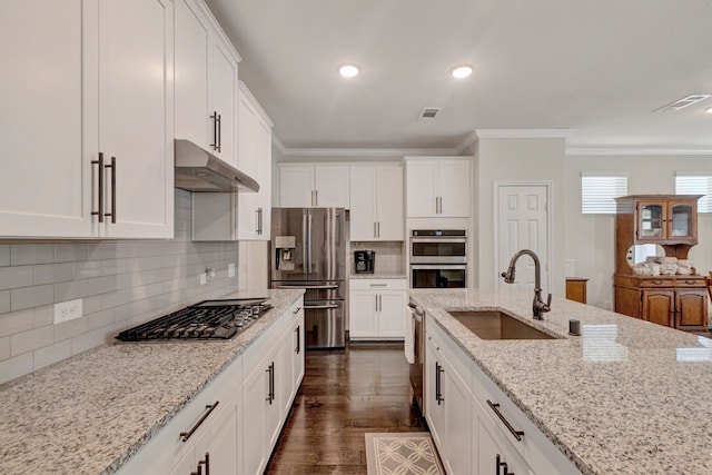 kitchen featuring crown molding, sink, light stone countertops, appliances with stainless steel finishes, and white cabinetry