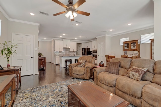 living room with dark hardwood / wood-style flooring, ceiling fan, and crown molding