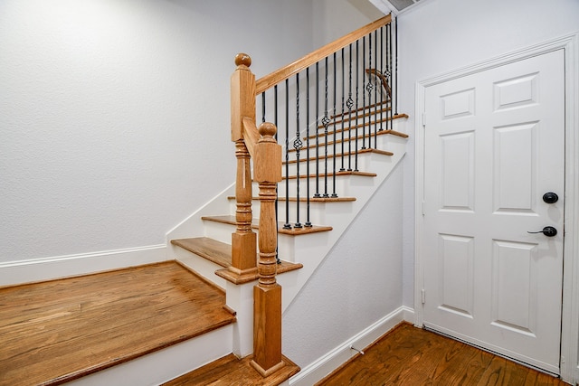 staircase with hardwood / wood-style floors