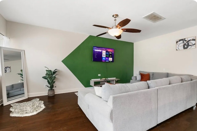 living room with ceiling fan and dark wood-type flooring