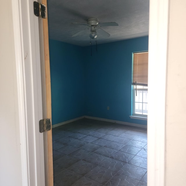 tiled spare room with ceiling fan