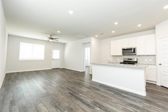 kitchen with white cabinets, dark hardwood / wood-style flooring, and stainless steel appliances