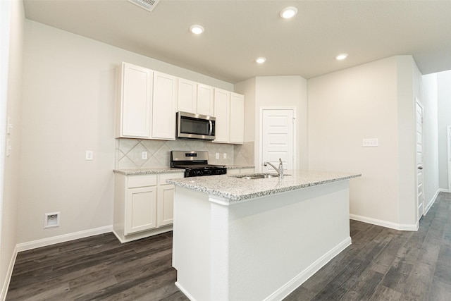 kitchen featuring appliances with stainless steel finishes, sink, white cabinetry, and an island with sink