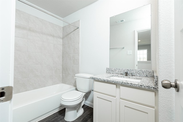 full bathroom featuring wood-type flooring, vanity, toilet, and tiled shower / bath