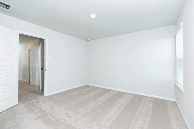 spare room with light carpet and a wealth of natural light