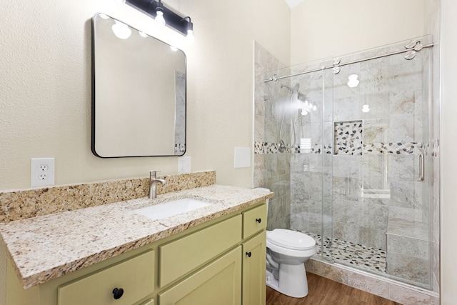 bathroom with hardwood / wood-style floors, vanity, toilet, and an enclosed shower