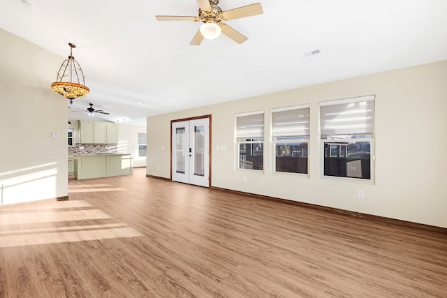 unfurnished living room featuring hardwood / wood-style floors and french doors