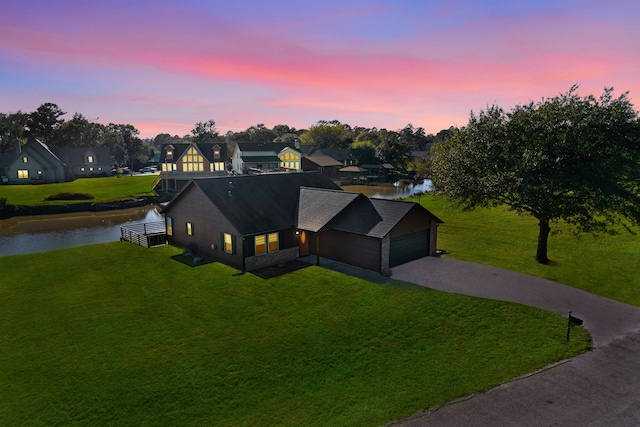 aerial view at dusk featuring a water view