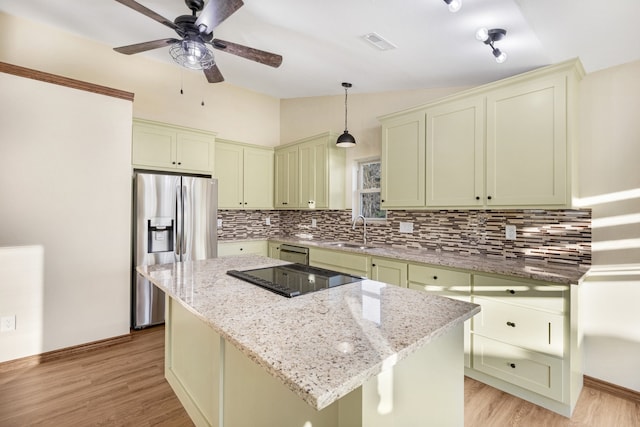 kitchen with pendant lighting, a center island, light stone countertops, and appliances with stainless steel finishes